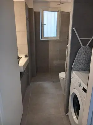 a bathroom with a toilet and a washing machine at Leo Athens Apartment Near Tram Station in Athens