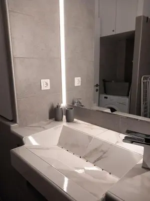 a bathroom with a sink and a large mirror at Leo Athens Apartment Near Tram Station in Athens