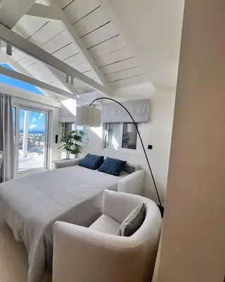 a white bedroom with a bed and a couch at Luxury Penthouse w/ sea view in Athens