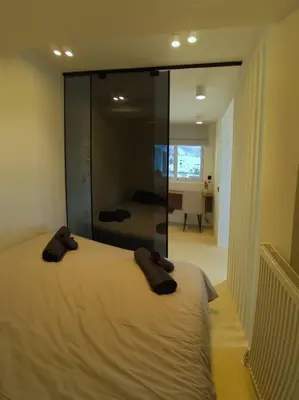 a bedroom with a large bed with glass walls at Luxury Penthouse w/ sea view in Athens