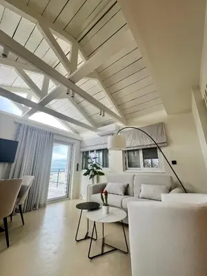 a living room with a white couch and a table at Luxury Penthouse w/ sea view in Athens
