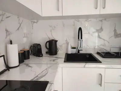 a white kitchen with a sink and a counter at Elegant & Modern Apartment near to Athens Riviera in Piraeus