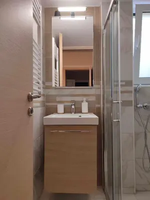 a bathroom with a sink and a mirror and a shower at Elegant & Modern Apartment near to Athens Riviera in Piraeus