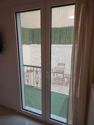 a sliding glass door with a view of a balcony at Elegant & Modern Apartment near to Athens Riviera in Piraeus