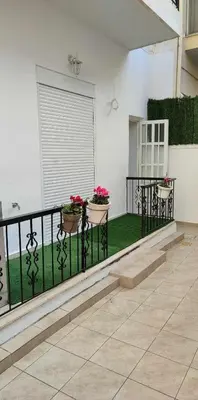 a balcony with two potted plants on a fence at Elegant & Modern Apartment near to Athens Riviera in Piraeus