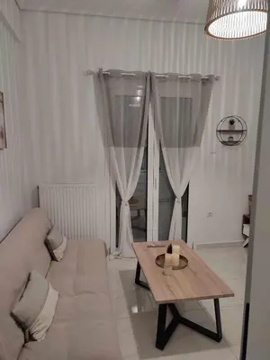 a living room with a couch and a table at Elegant & Modern Apartment near to Athens Riviera in Piraeus