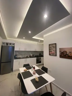 a kitchen with a table with chairs and a refrigerator at Alexandra apartment in Athens