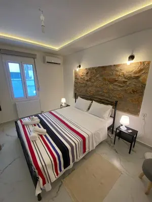 a bedroom with a large bed and a stone wall at Alexandra apartment in Athens