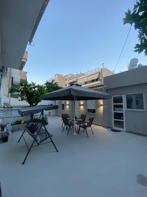 a patio with tables and umbrellas on a building at Alexandra apartment in Athens