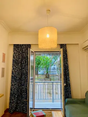 a living room with a window and a glass door at Antinoros Inn, Stylish apartment,3' to Metro in Athens