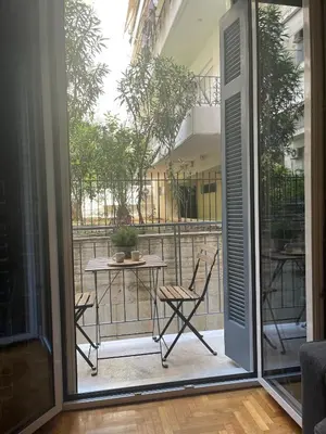 a patio with a table and chairs on a balcony at Antinoros Inn, Stylish apartment,3' to Metro in Athens