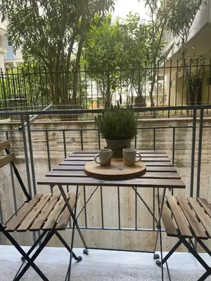 a wooden table with two cups and two chairs at Antinoros Inn, Stylish apartment,3' to Metro in Athens