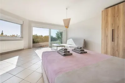 a bedroom with a large bed with a pink blanket at Serenity Villa by Comfortbnb in Saronida