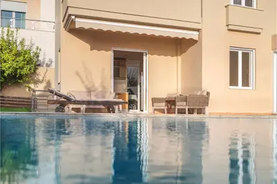 a swimming pool in front of a house at Serenity Villa by Comfortbnb in Saronida