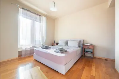 a white bedroom with a bed and a window at Serenity Villa by Comfortbnb in Saronida