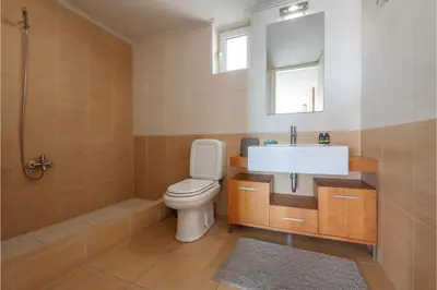 a bathroom with a toilet and a sink and a shower at Serenity Villa by Comfortbnb in Saronida