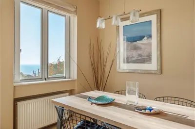 a dining room with a table and two windows at Serenity Villa by Comfortbnb in Saronida