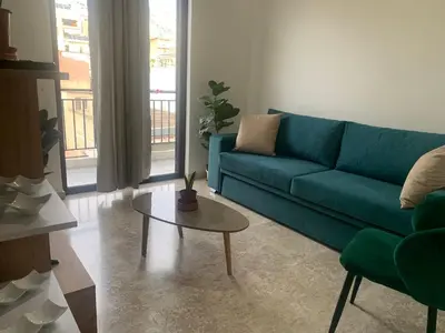 a living room with a green couch and a table at Calma apartment in Athens