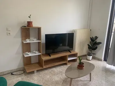 a living room with a flat screen tv on a wooden entertainment center at Calma apartment in Athens