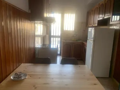 a kitchen with a wooden table and a white refrigerator at Calma apartment in Athens