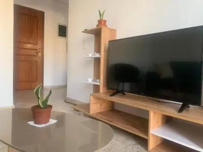 a large flat screen tv sitting on a wooden entertainment center at Calma apartment in Athens