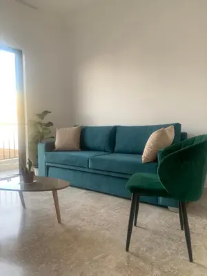 a living room with a blue couch and a table at Calma apartment in Athens