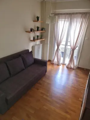 a living room with a couch and a wooden floor at athens.apartotel.3 in Athens