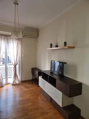a living room with a tv and a large window at athens.apartotel.3 in Athens