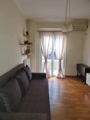a living room with a couch and a large window at athens.apartotel.3 in Athens