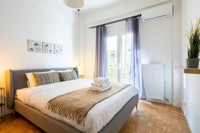 a bedroom with a bed and a large window at Mystique 2-Bedroom Apartment in Athens in Athens