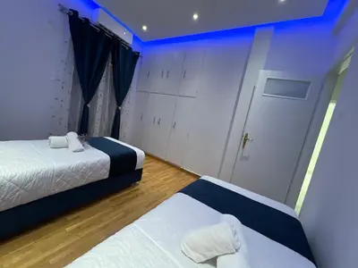 a room with two beds and a door in it at Four Seasons Apartment in Athens