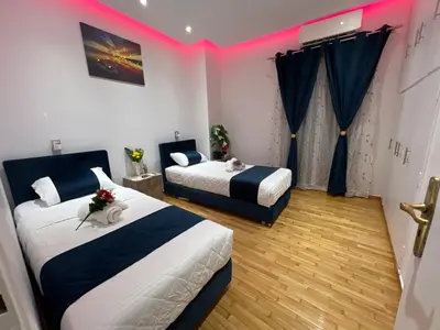 two beds in a room with pink lighting at Four Seasons Apartment in Athens
