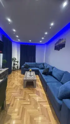 a living room with a blue couch and a table at Four Seasons Apartment in Athens