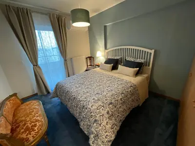 a bedroom with a large bed and a window at VERA’S APARTMENT in Markopoulo