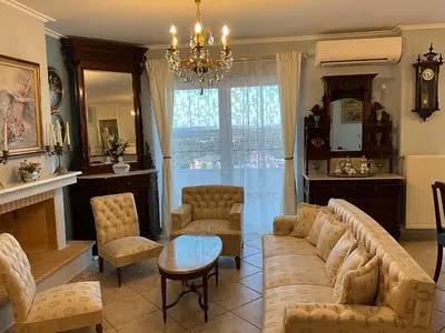 a living room with a couch and chairs and a chandelier at VERA’S APARTMENT in Markopoulo