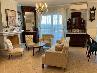 a living room with a couch and chairs and a table at VERA’S APARTMENT in Markopoulo
