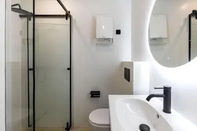 a bathroom with a toilet and a sink and a mirror at The Met by Zoia Living in Athens