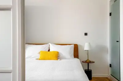 a bedroom with a white bed with a yellow pillow at The Met by Zoia Living in Athens