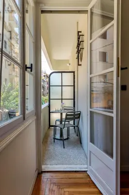 a balcony with a table and a chair in a room at The Met by Zoia Living in Athens