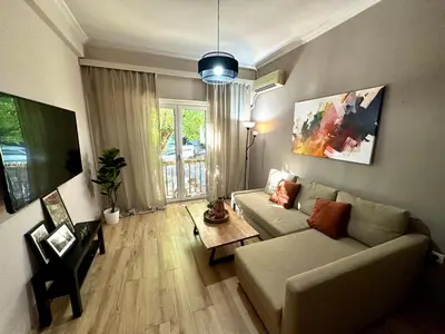 a living room with a couch and a table at Your Cozy Home in Athens in Athens