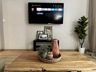 a living room with a flat screen tv on a wall at Your Cozy Home in Athens in Athens