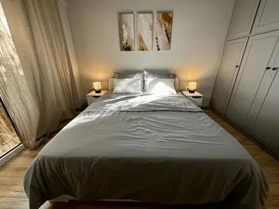 a bedroom with a large bed with two lamps on tables at Your Cozy Home in Athens in Athens
