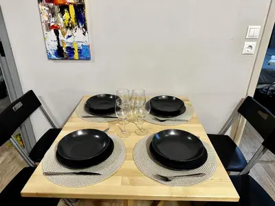 a wooden table with black plates and wine glasses at Your Cozy Home in Athens in Athens
