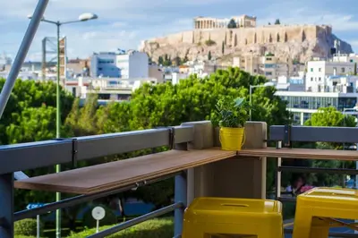 a wooden bench with a potted plant sitting on it at Front-Row Acropolis View Balcony - Central Athens in Athens