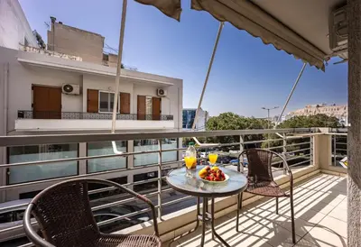 a table with a bowl of fruit on a balcony at Front-Row Acropolis View Balcony - Central Athens in Athens