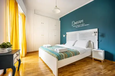 a bedroom with a white bed with a blue wall at Stunning Acropolis View from a Sunny Renovated Apartment in Athens