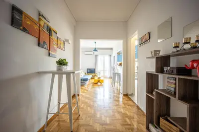 a living room with a table in the middle of a room at Stunning Acropolis View from a Sunny Renovated Apartment in Athens