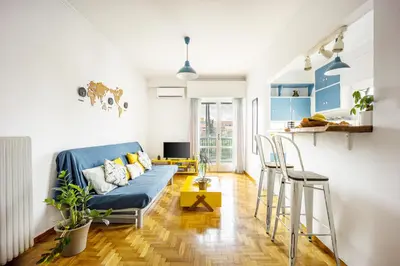 a living room with a blue couch and chairs at Stunning Acropolis View from a Sunny Renovated Apartment in Athens