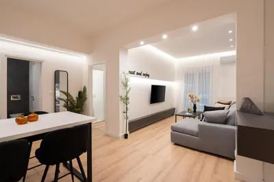 a white living room with a couch and a table at Exclusive and Deluxe Apartment in Athens City in Athens