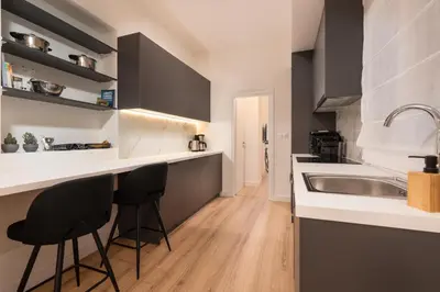 a kitchen with a sink and two bar stools at Exclusive and Deluxe Apartment in Athens City in Athens